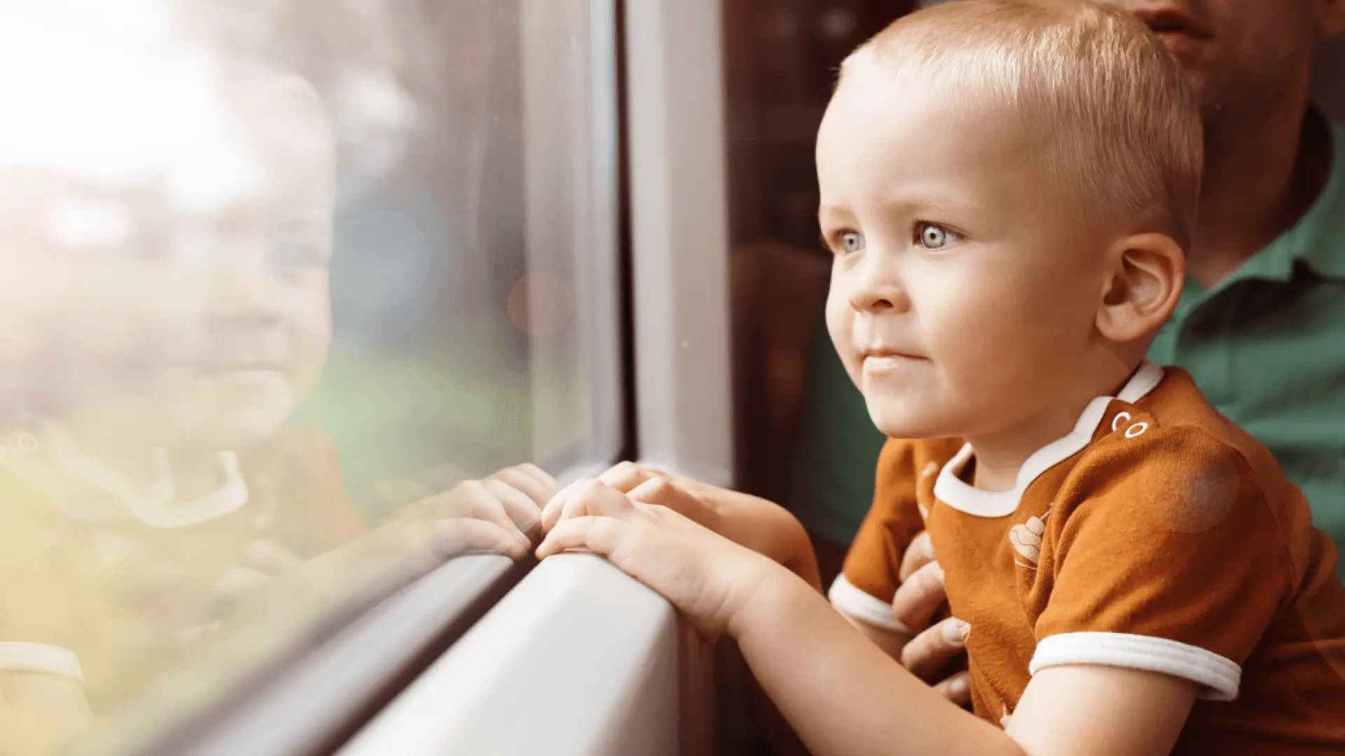 На фото зображено хлопчика, що дивиться у вікно в поїзді