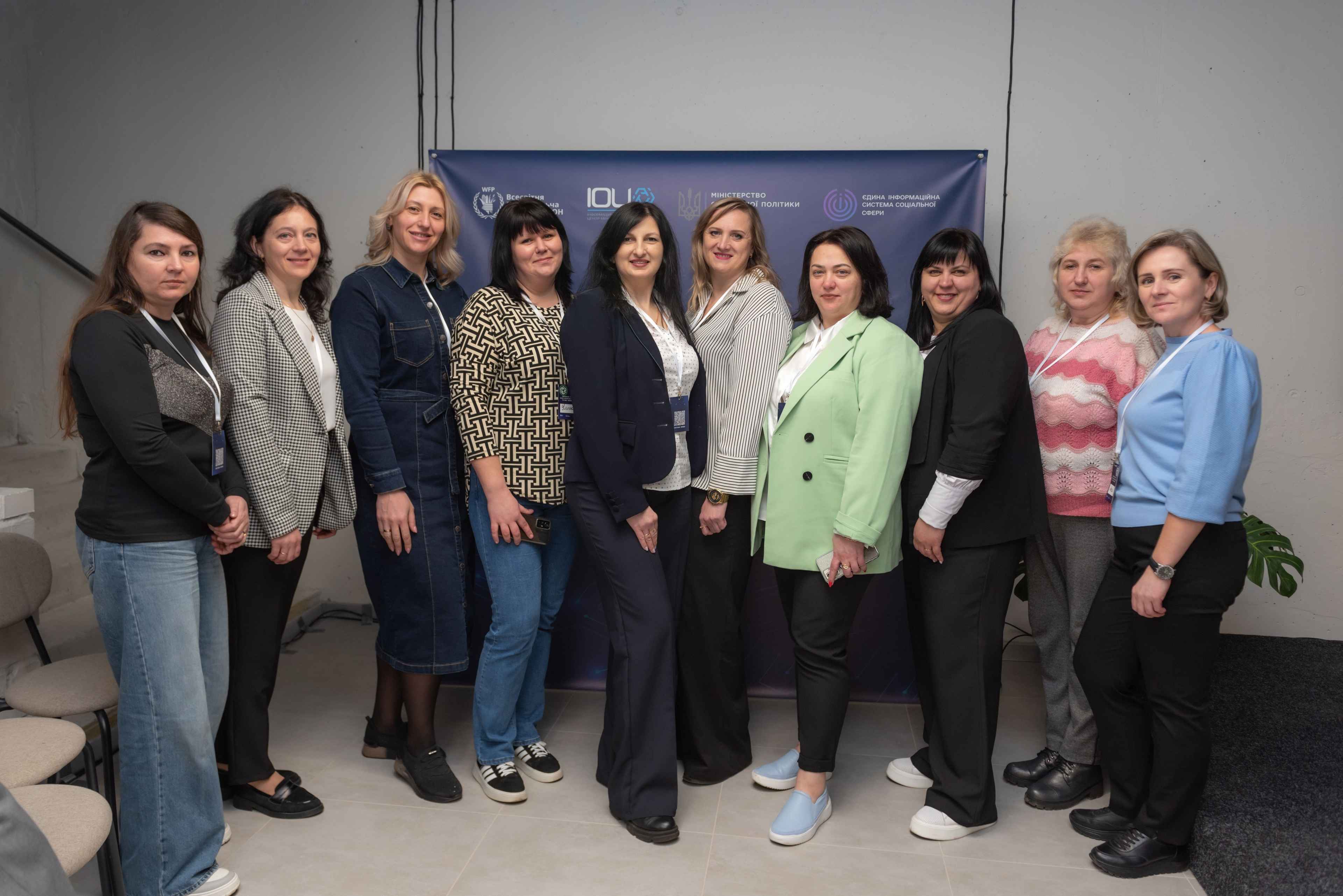 Учасниці семінару «ЄІССС: оптимізація роботи та нові можливості» стоять на фоні банеру