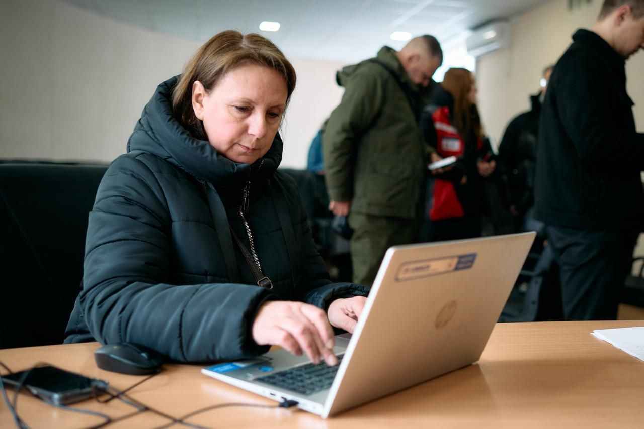 На фото жінка працює за ноутбуком