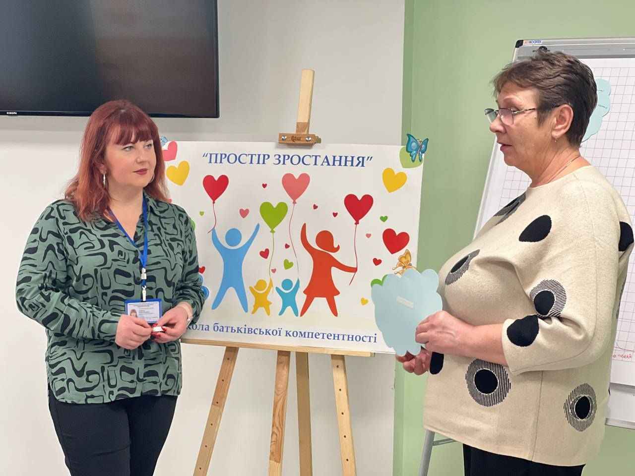 Двоє жінок стоять біля фліпчарту з написом "Простір зростання"