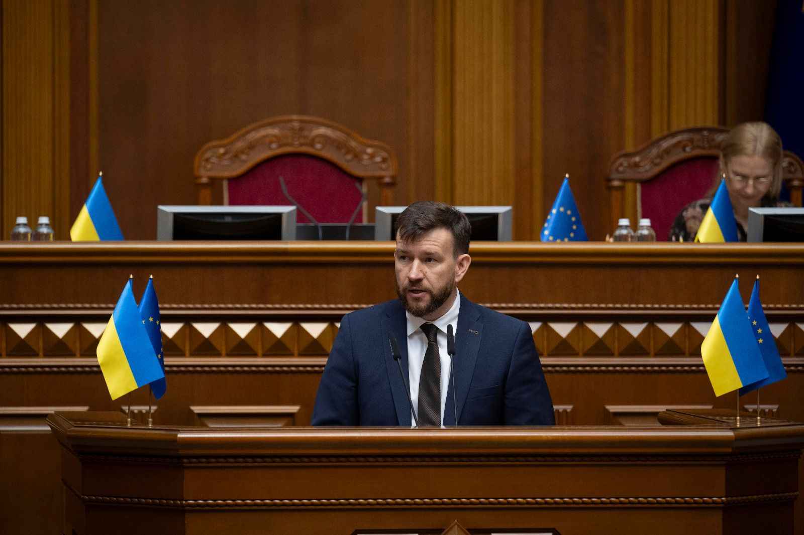 На фото Міністр соціальної політики, сім"ї та єдності Денис Улютін виступає за трибуною у Верховній Раді України