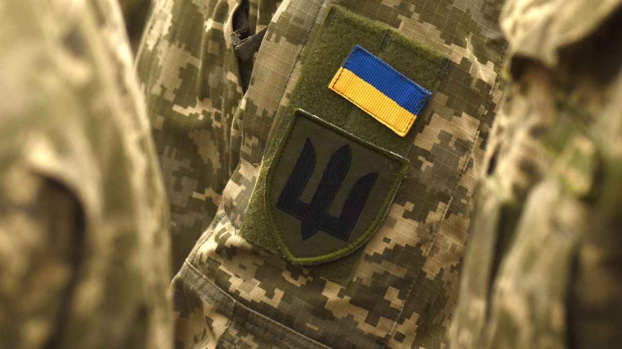 На зображенні військова форма з прапором та тризубом
