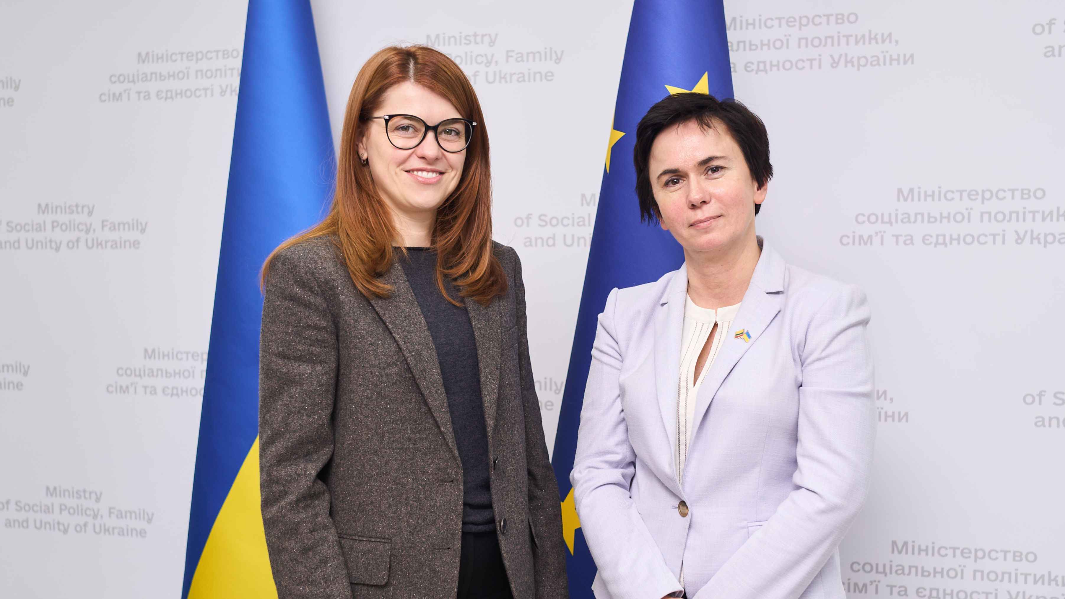 На фото жінки стоять на фоні прапорів України та ЄС