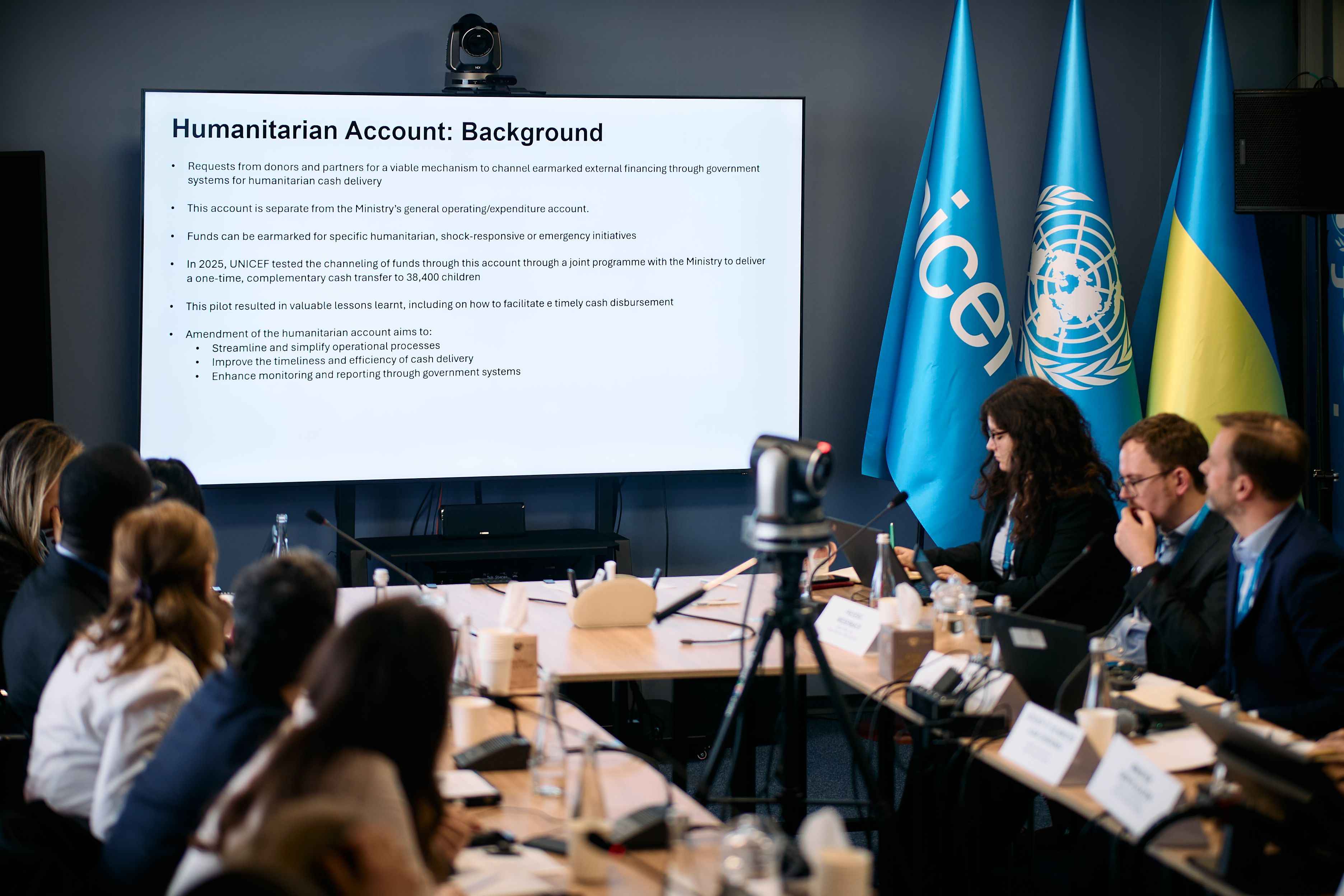 На фото чоловіки та жінки сидять за столом під час заходу