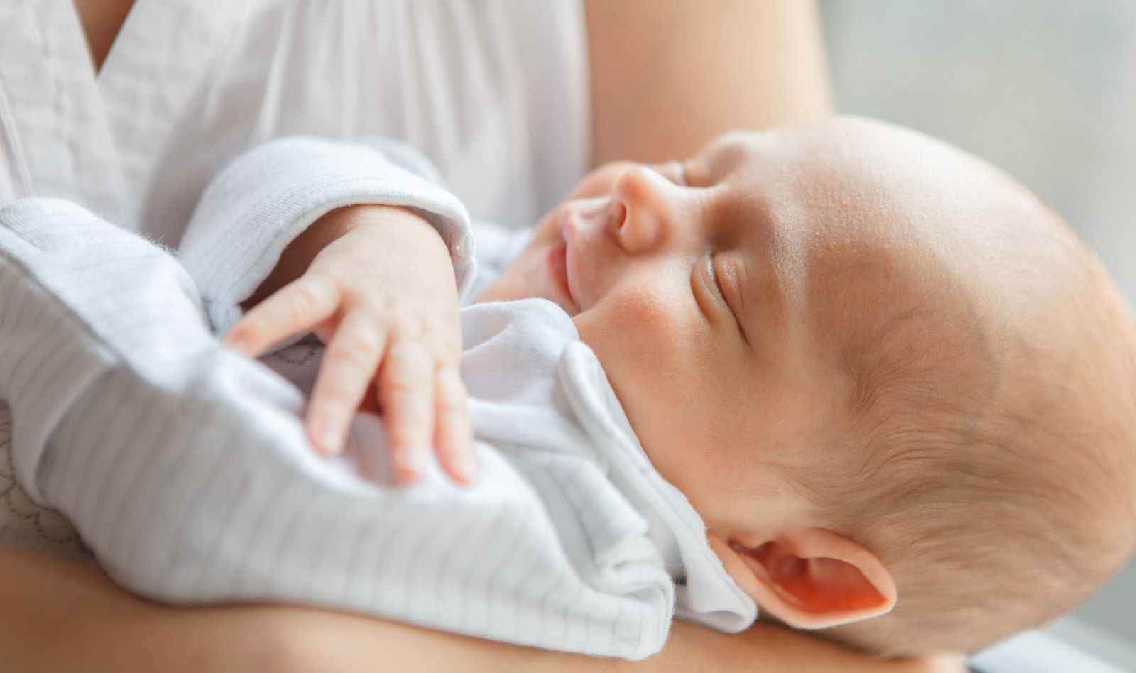 На фото мама тримає немовля на руках