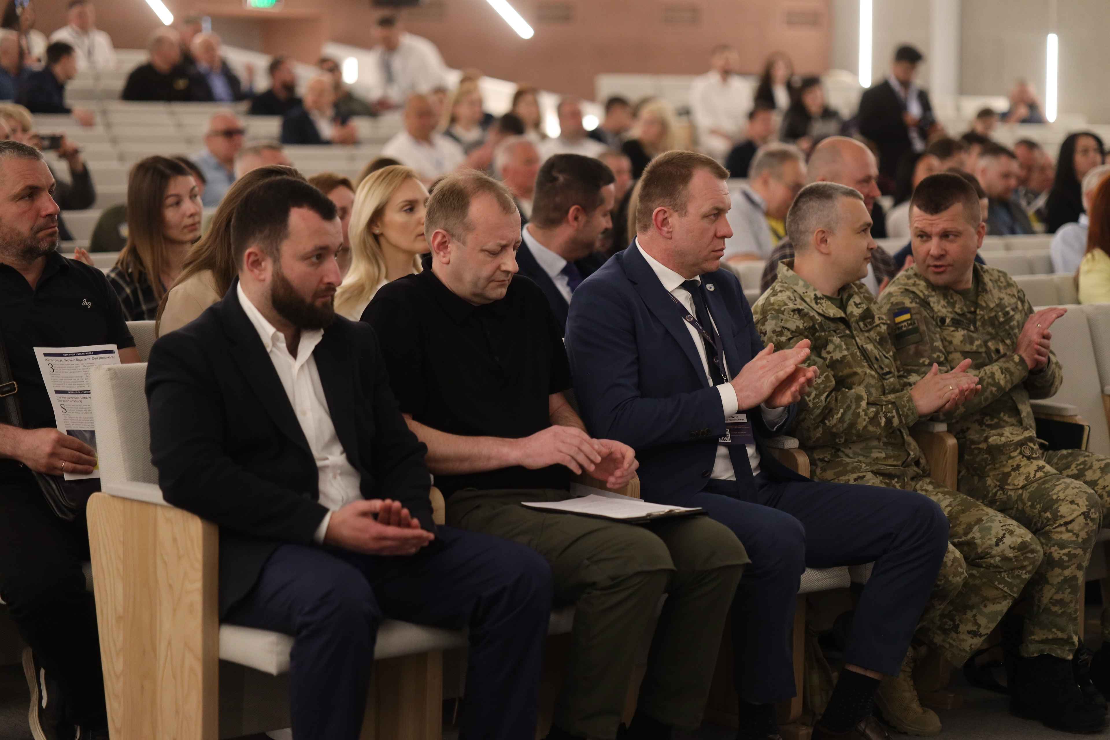 На зображенні багато людей сидять в залі. На заході заступник Міністра Володимир Василенко