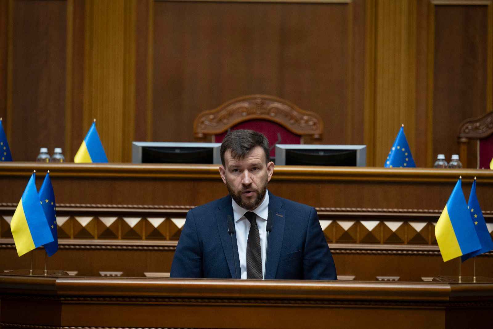 На фото Міністр соціальної політики, сім"ї та єдності Денис Улютін виступає за трибуною у Верховній Раді України