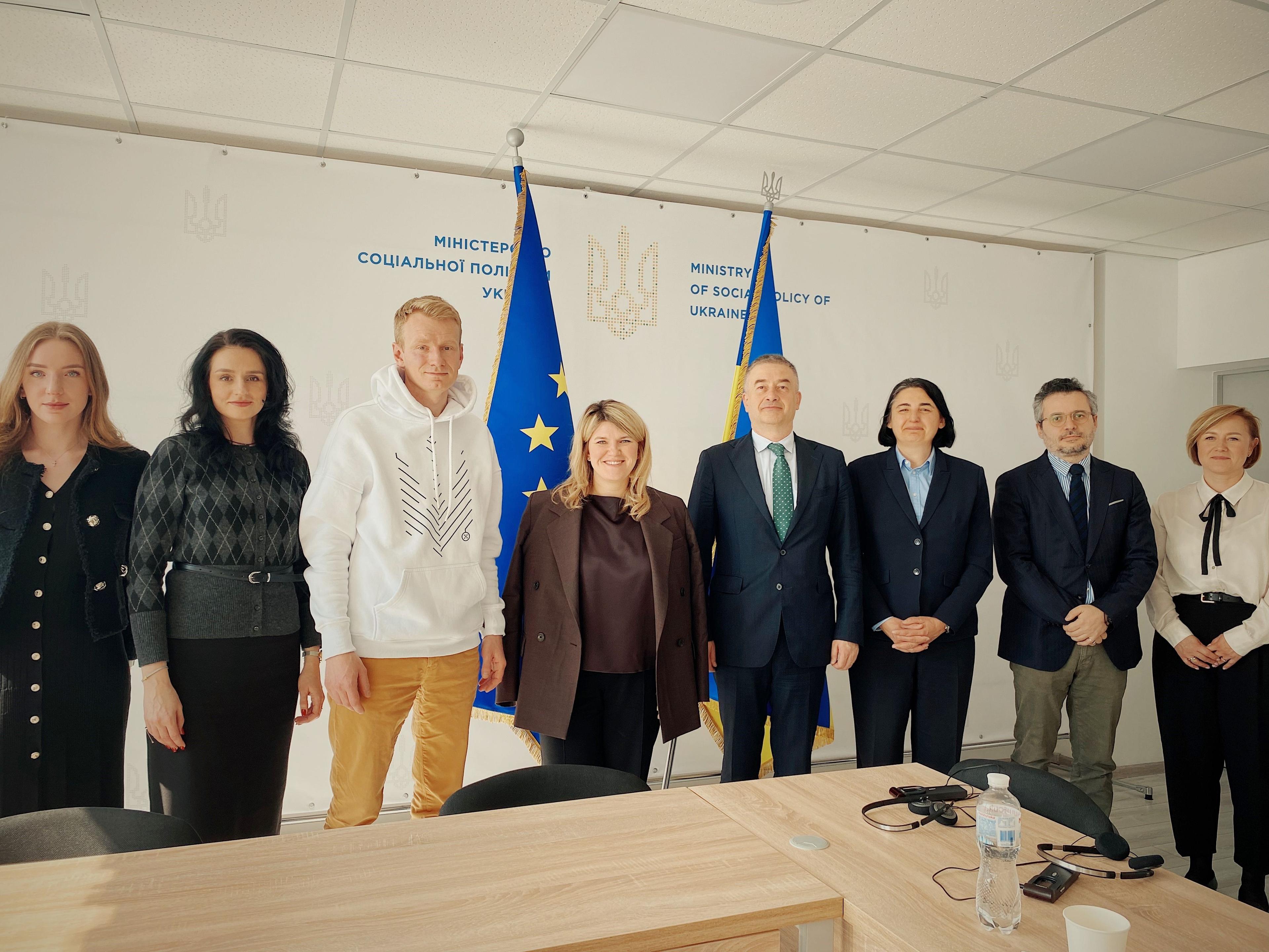 Учасники зустрічі стоять на фоні прапорів України та ЄС