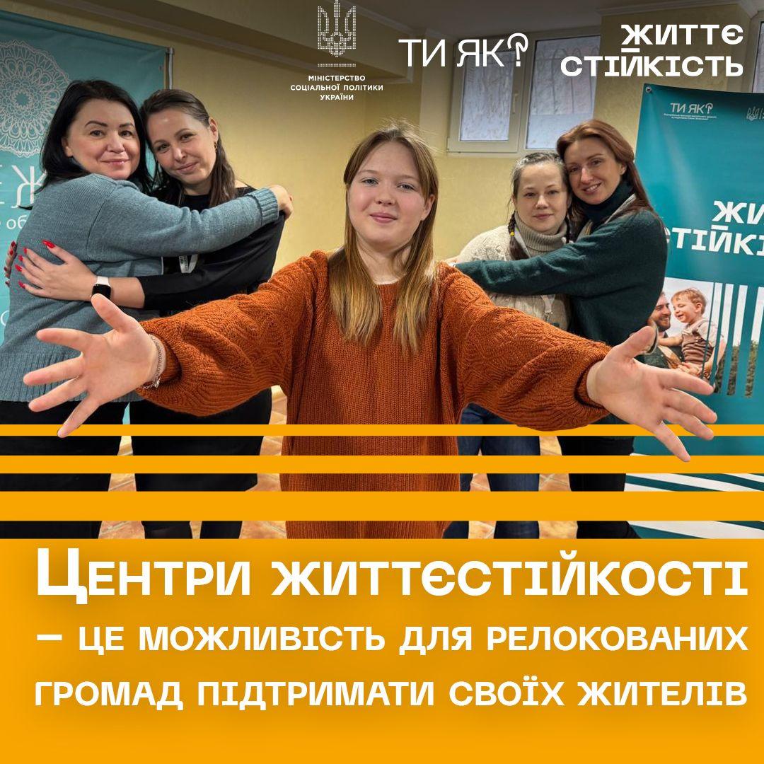 Група молодих людей обіймається і позує на фоні постера з текстом "Центри життєстійкості". На зображенні також вказано, що ці центри допомагають релокованим громадам підтримувати своїх жителів. Текст на фоні повідомляє про важливість таких центрів.