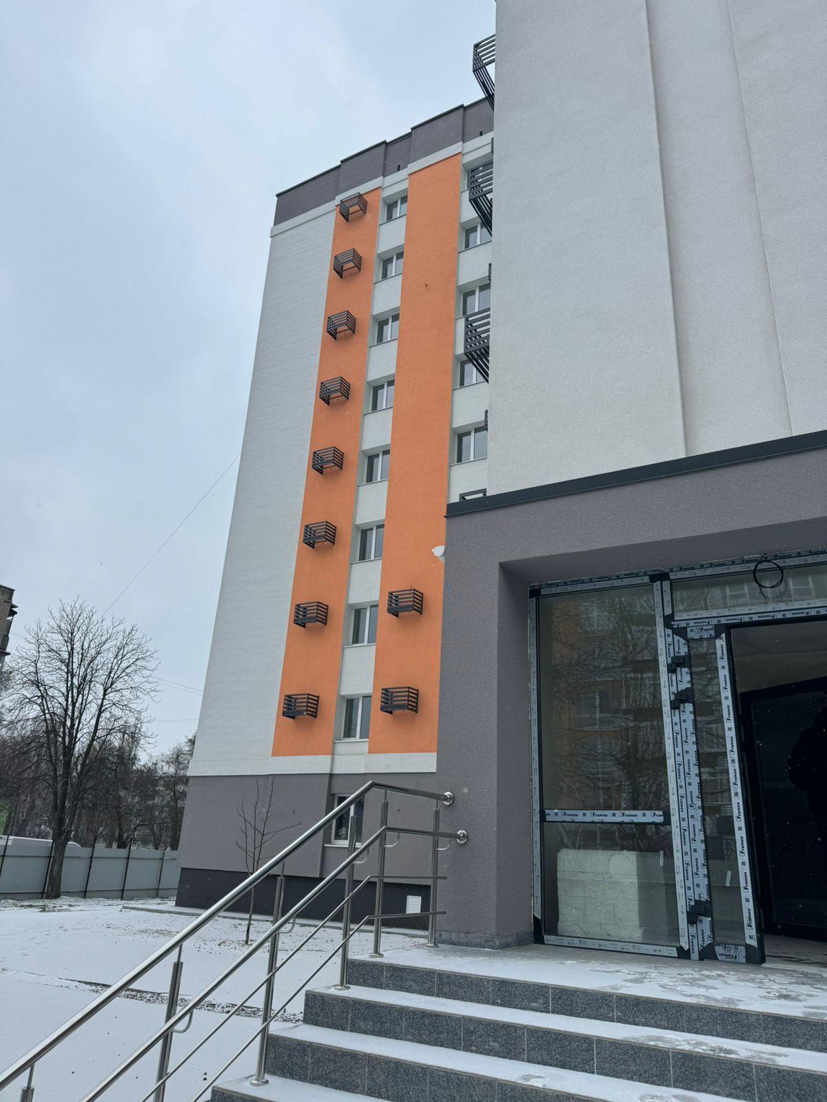 На фото зображено новий багатоповерховий будинок