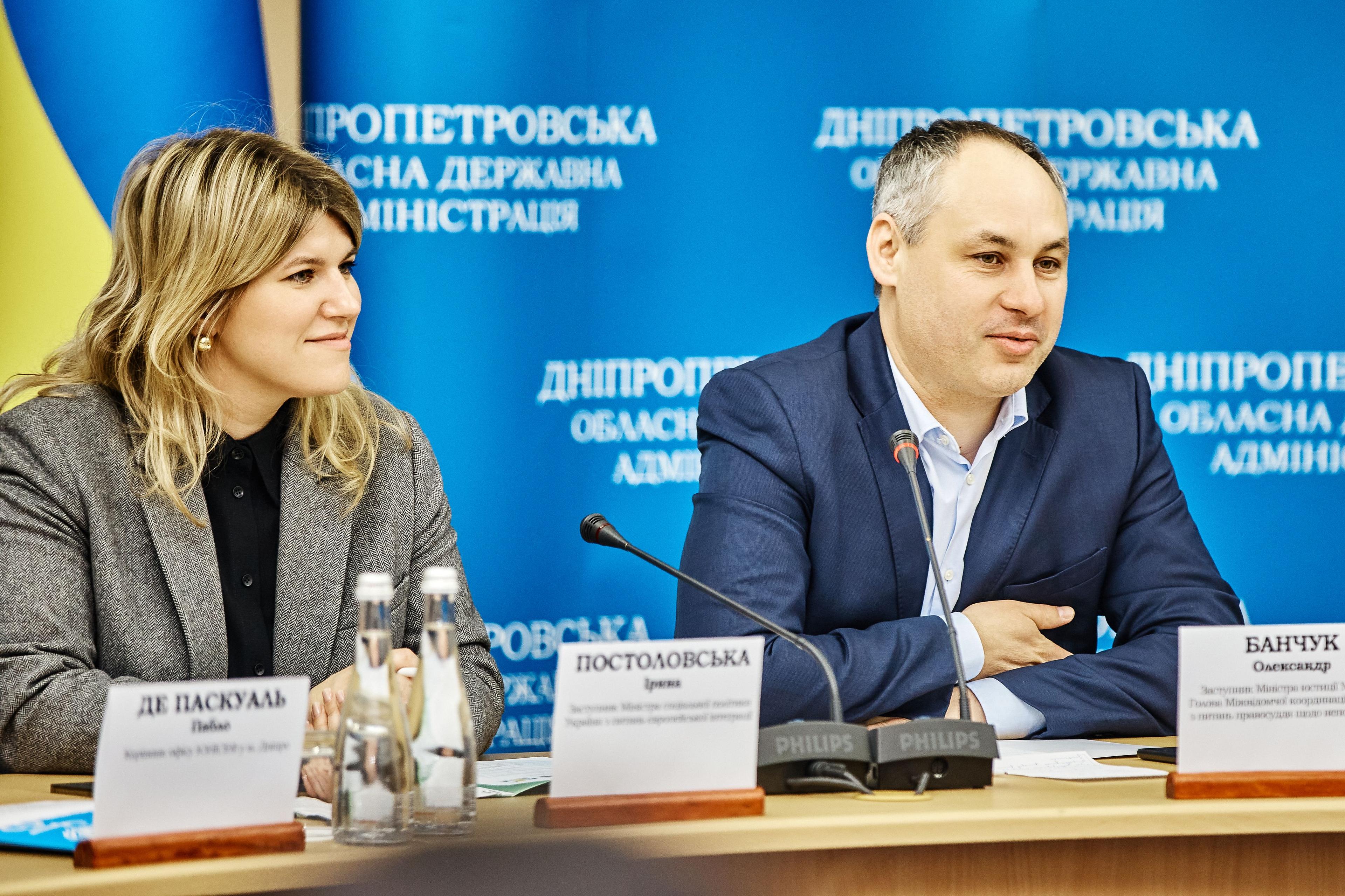 За столом сидять заступник Міністра соціальної політики з питань європейської інтеграції Ірина Постоловська та заступник Міністра юстиції Олександр Банчук