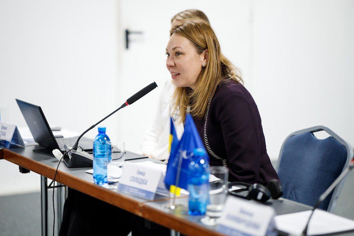 На фото жінка виступає перед учасниками заходу