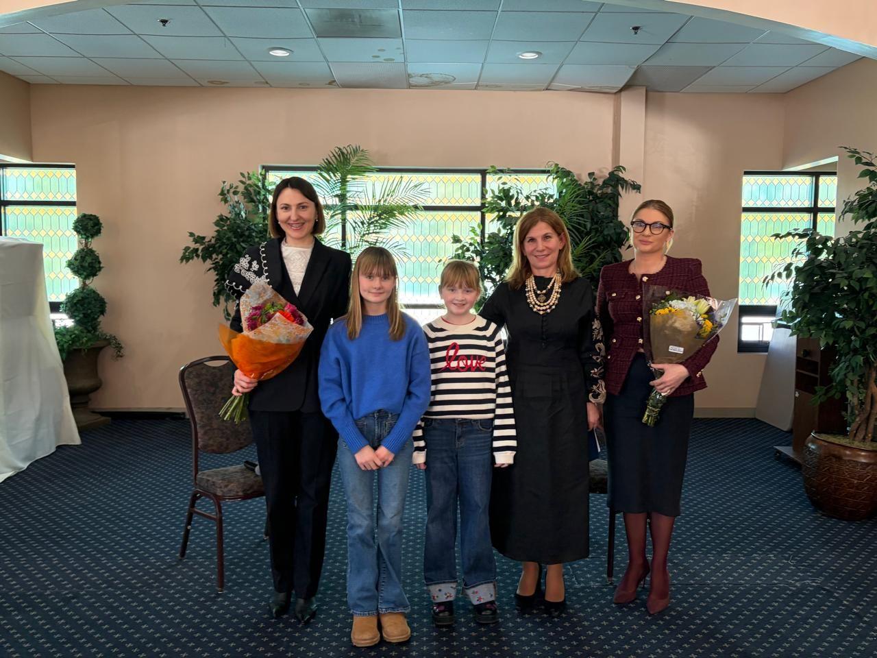 Ілона Гавронська стоїть поруч з дітьми та жінками