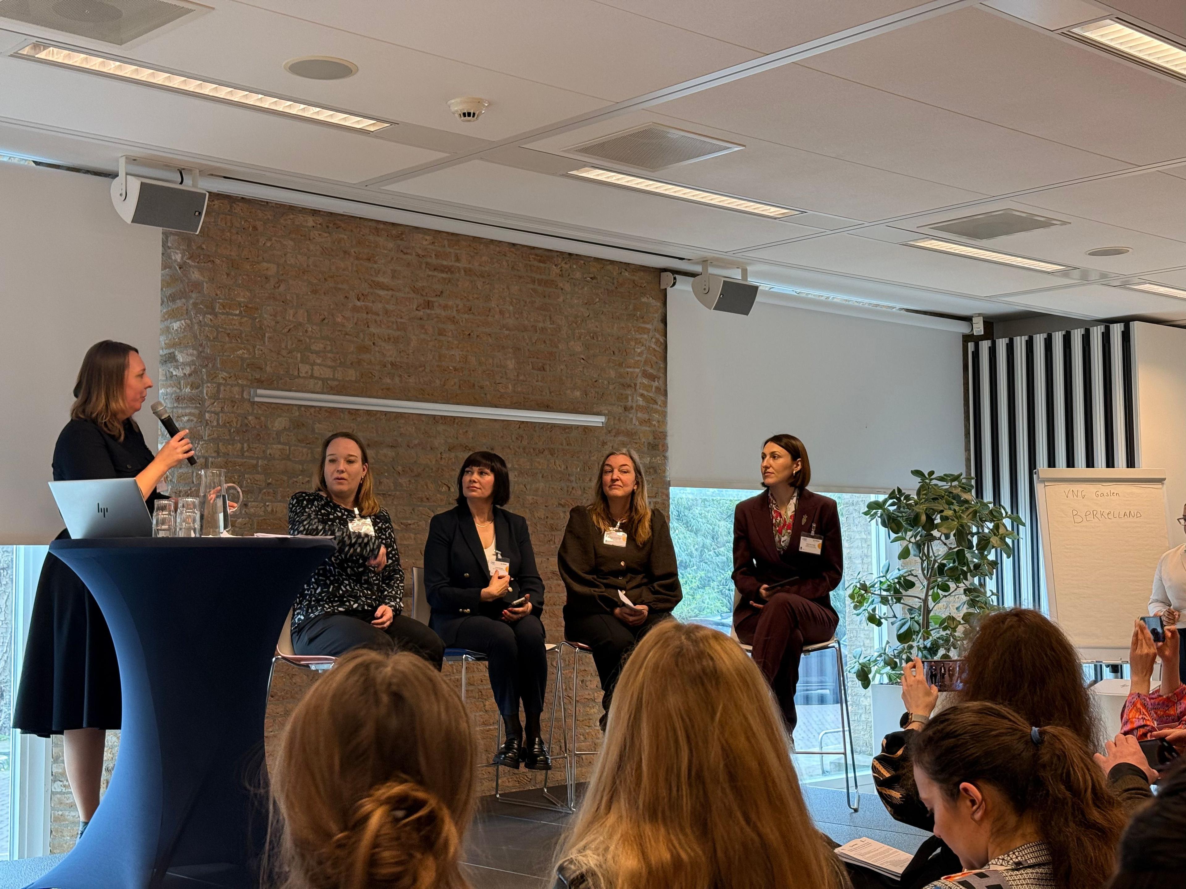 На фото жінки сидять в залі під час заходу