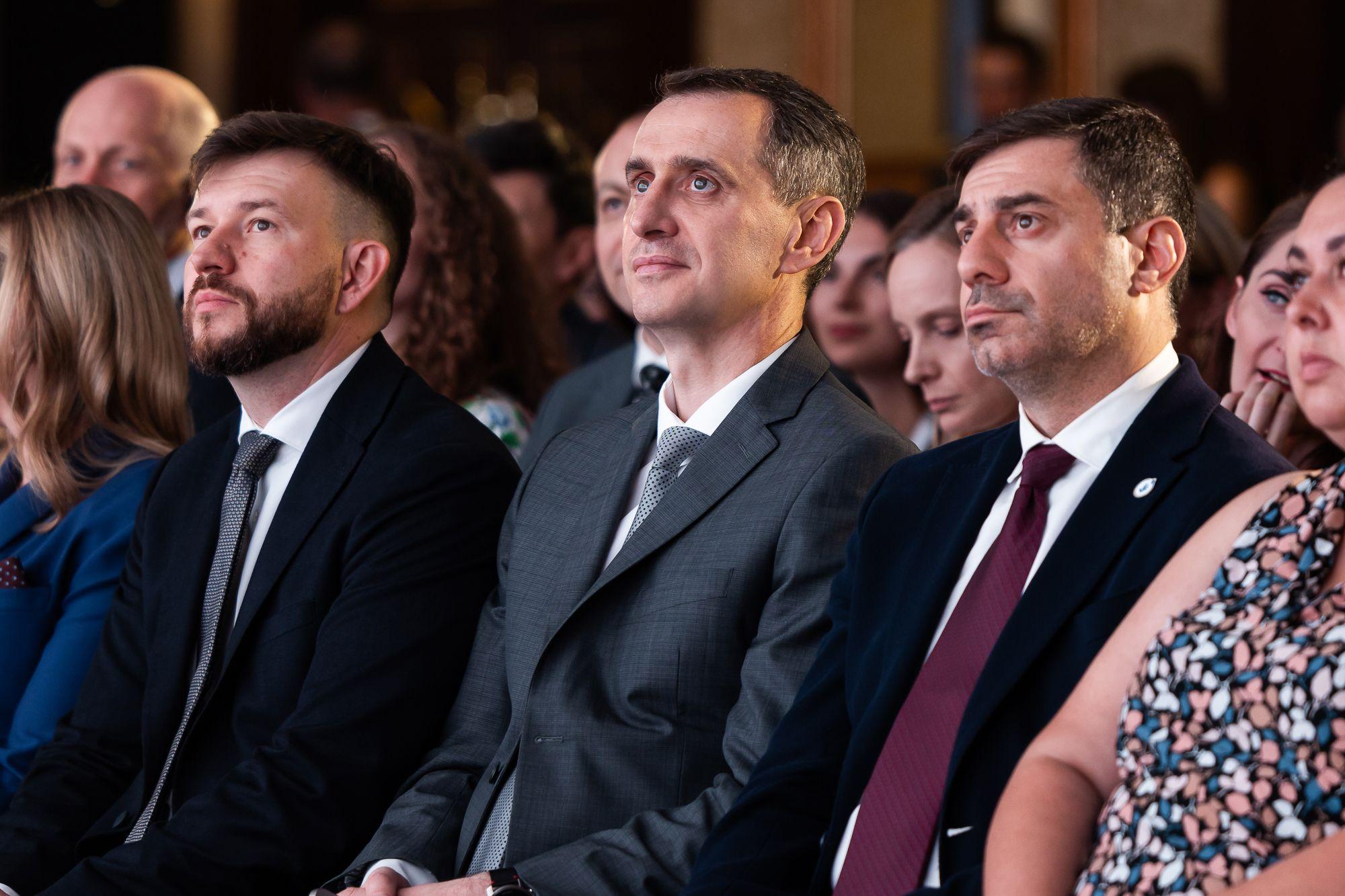 Чоловіки сидять у залі і уважно слухають