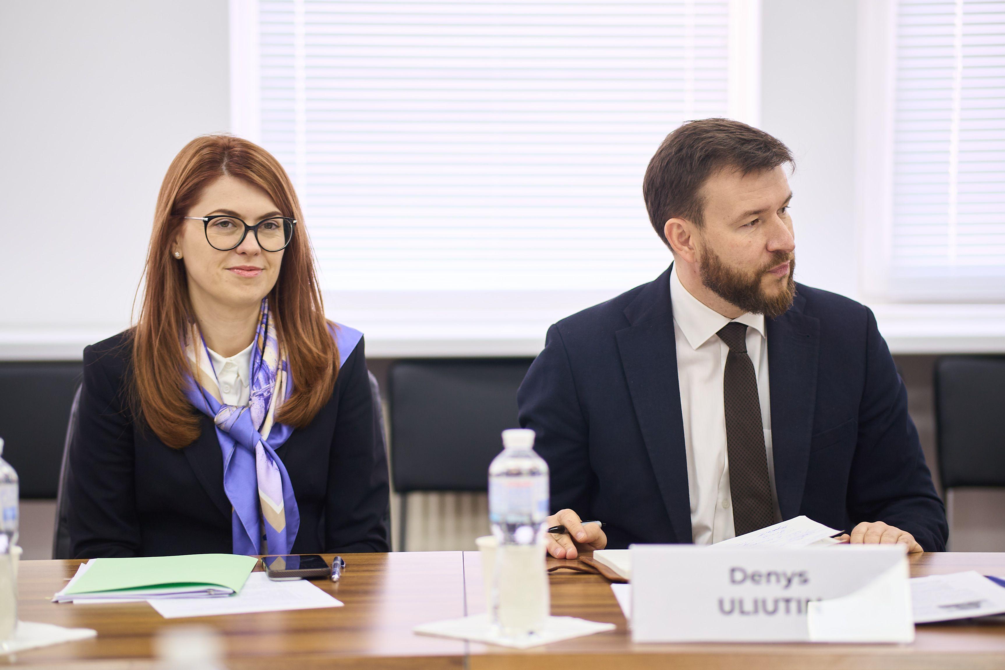 На фото чоловік та жінка сидять за столом під час зустрічі