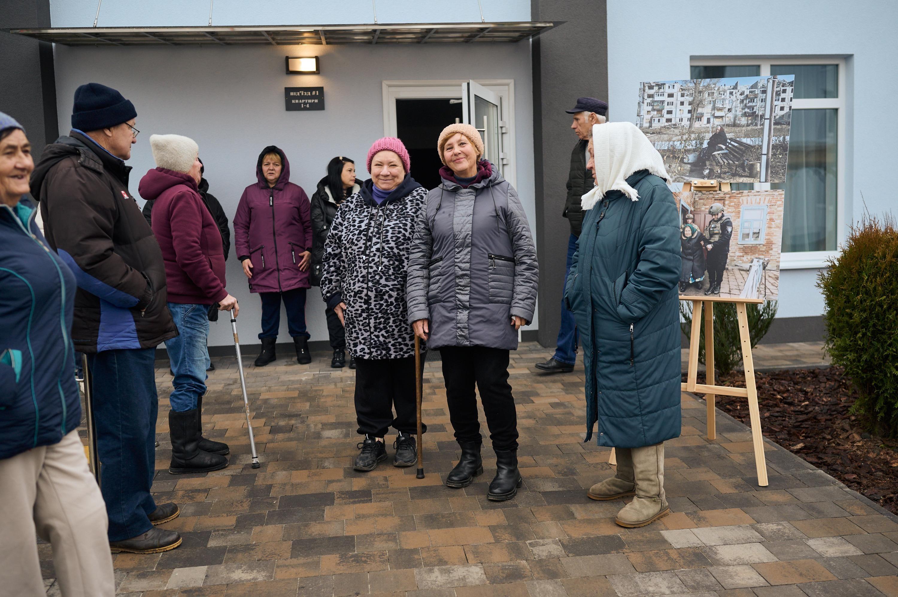На фото жінки та чоловіки спілкуються на вулиці