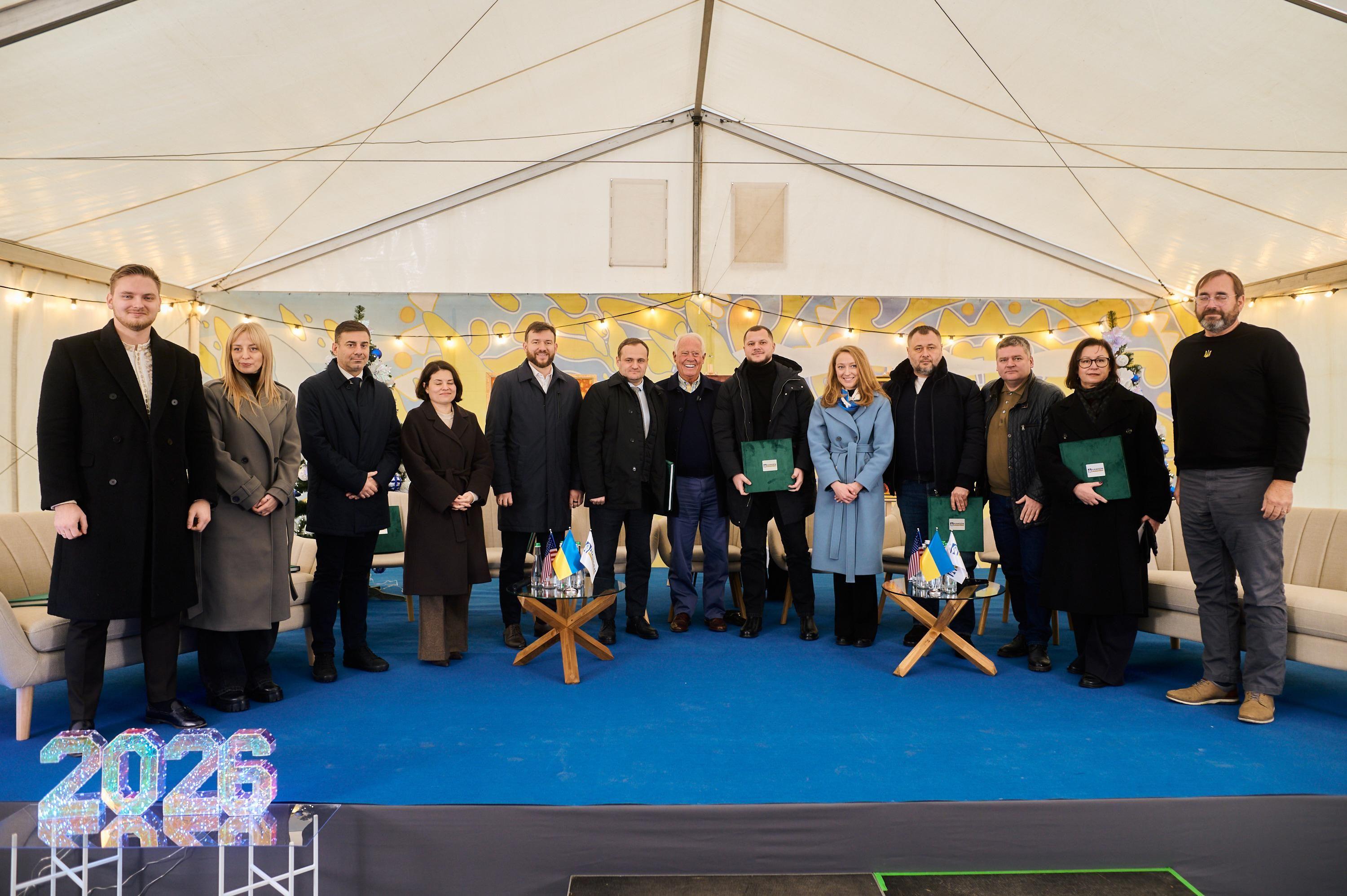 На фото жінки та чоловіки стоять у приміщенні