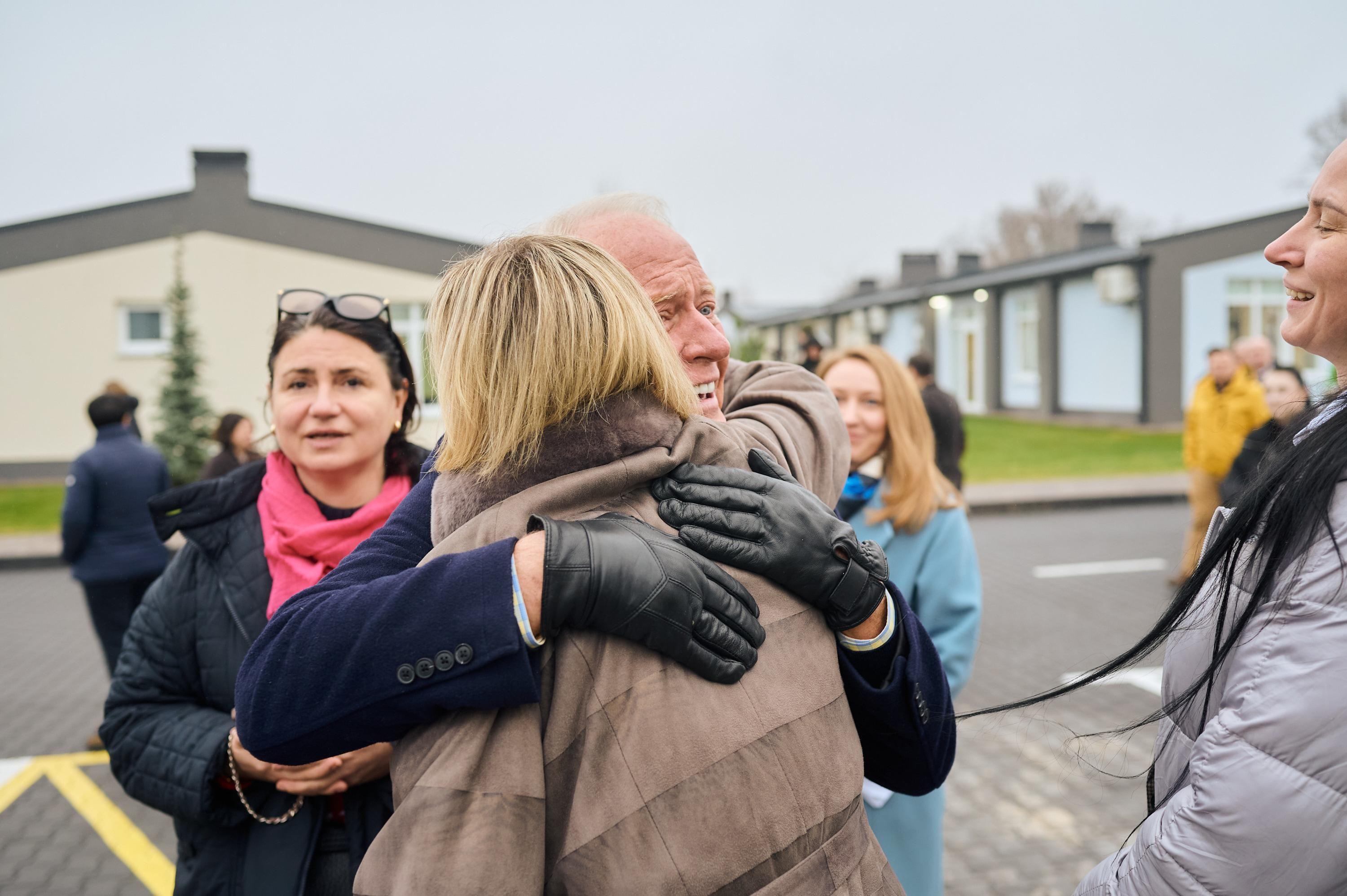 На фото чоловік обіймає жінку на вулиці