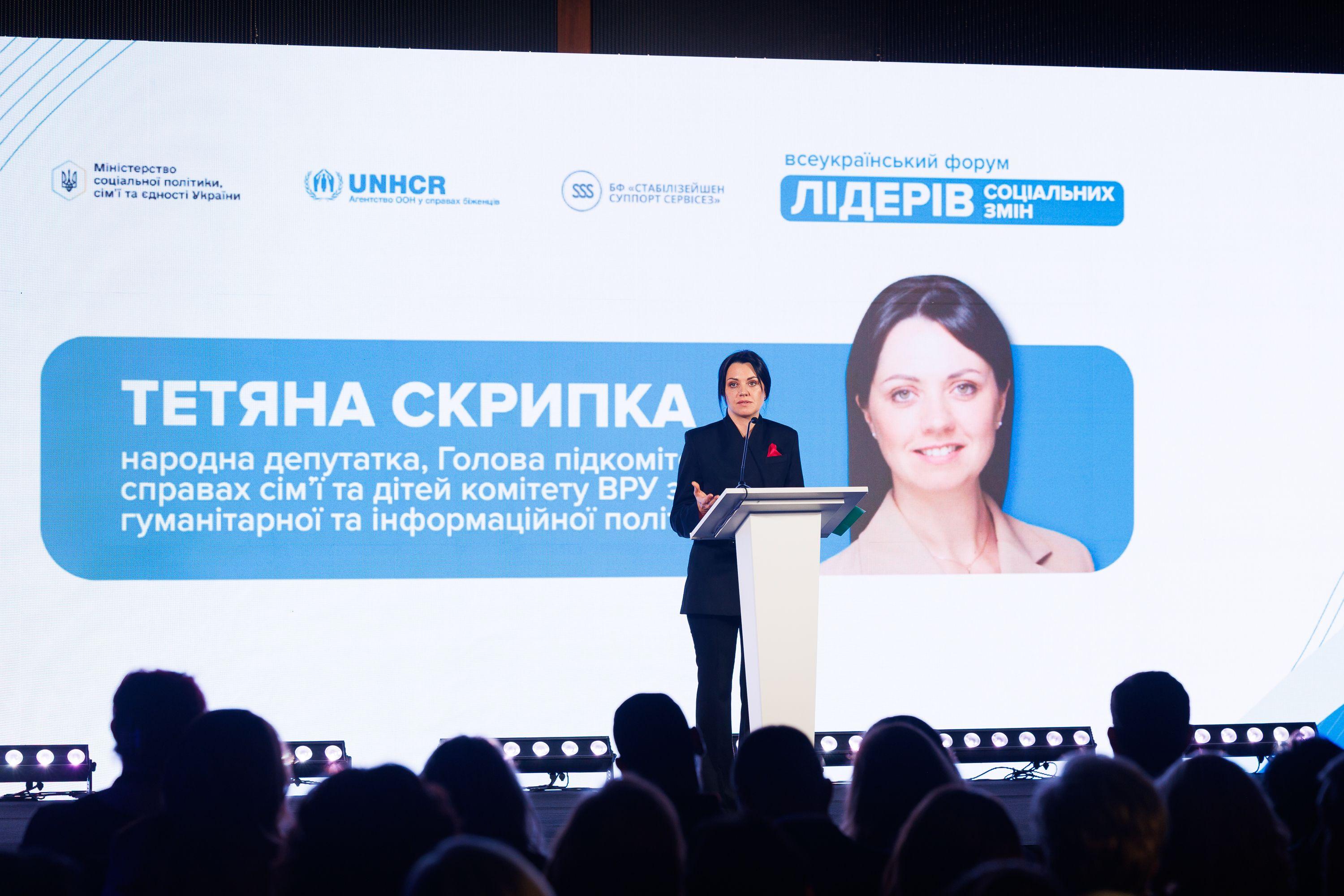 На фото жінка виступає перед учасниками Форуму