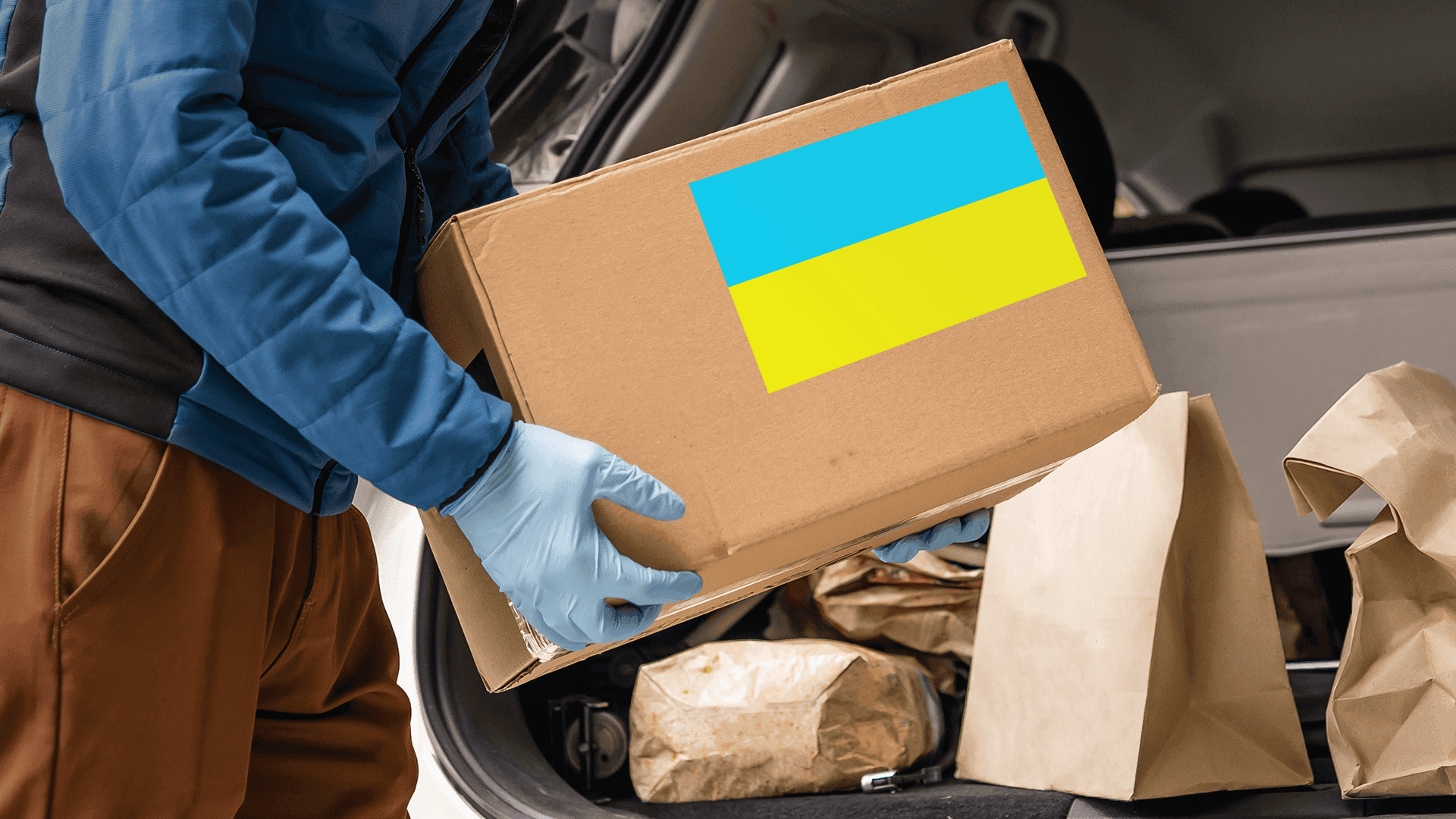 Людина тримає картонну коробку з прапором України
