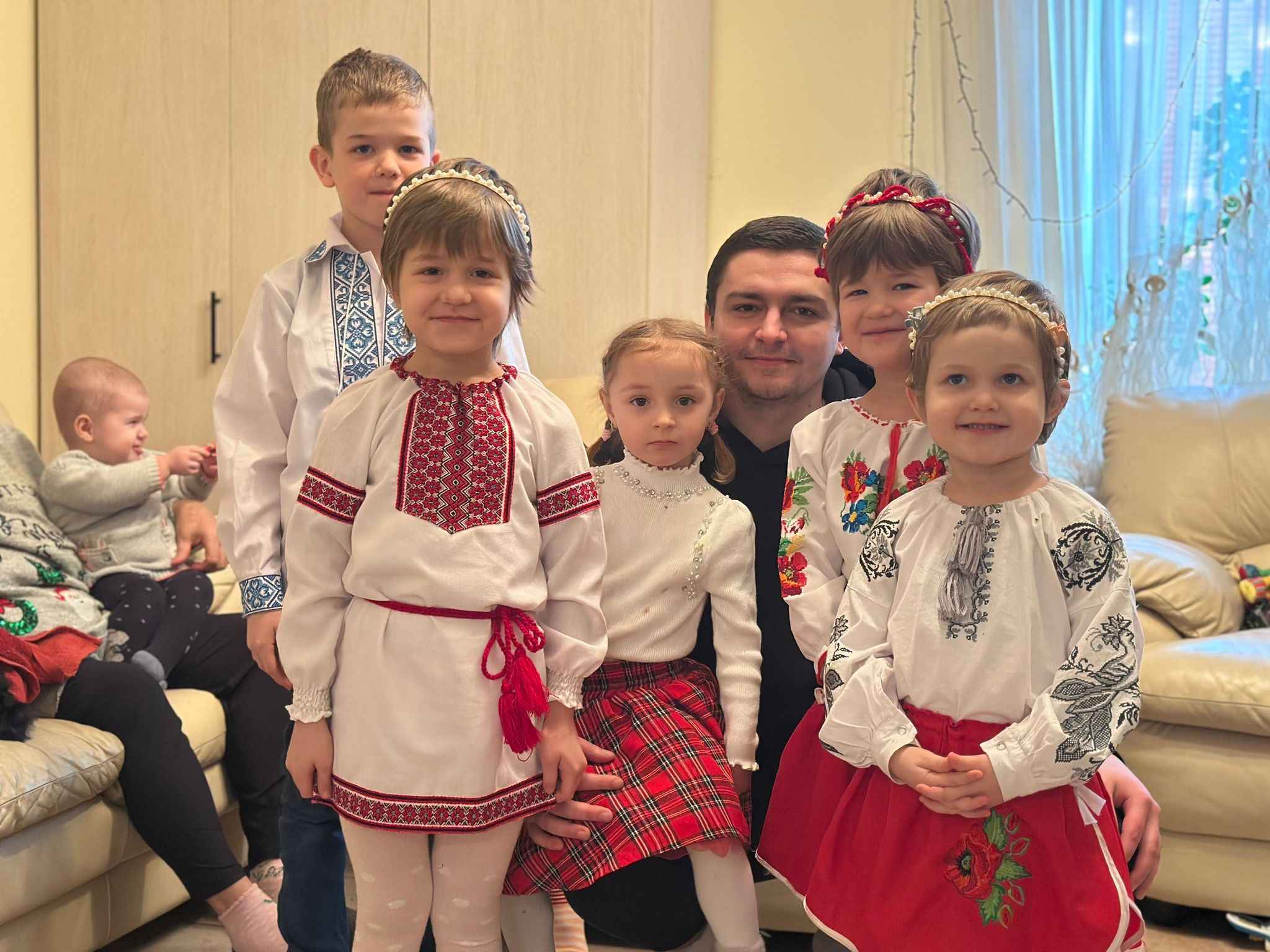 На фото чоловік та діти у вишиванках у кімнаті На фото чоловік та діти у вишиванках у кімнаті