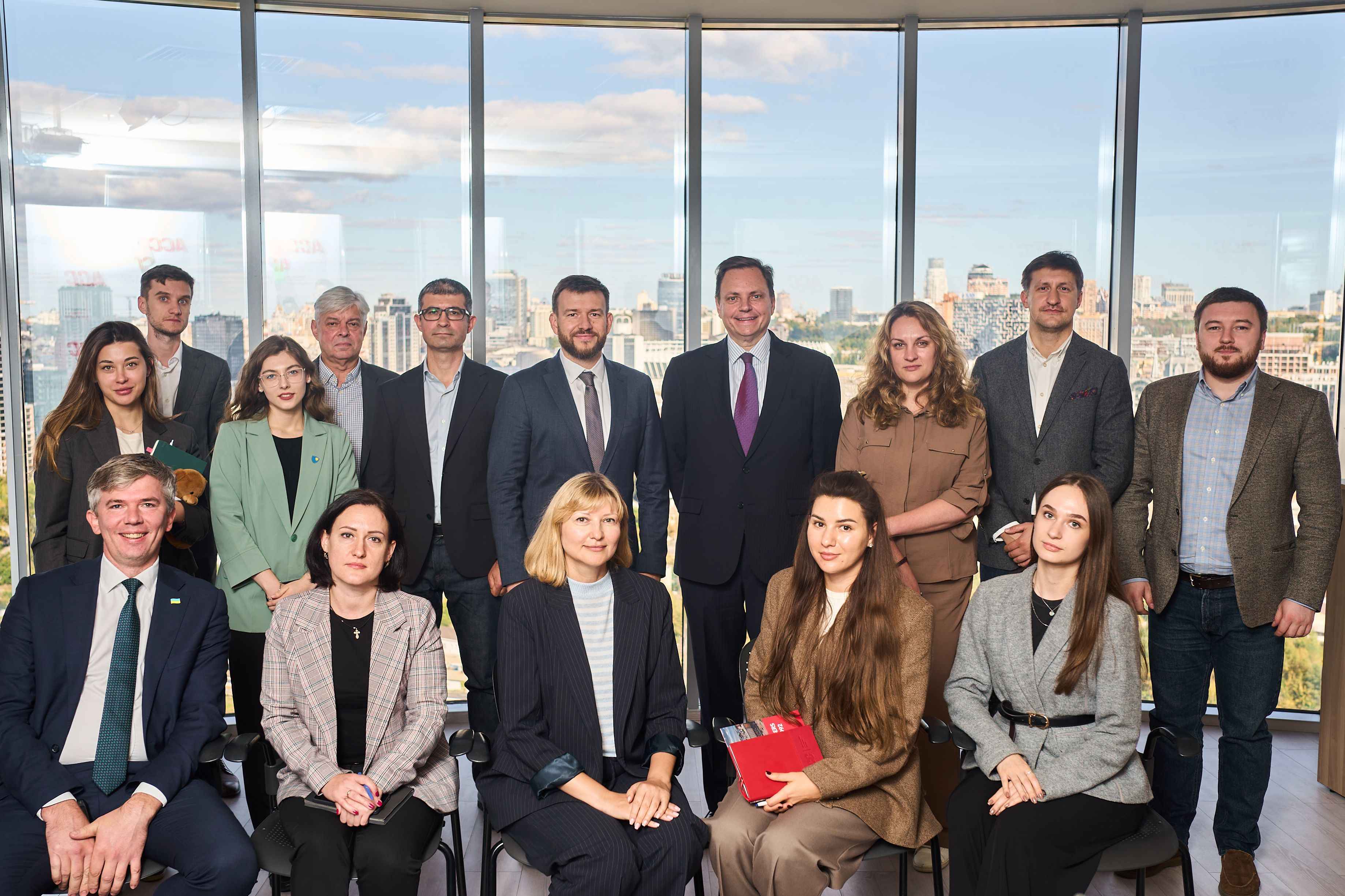 На фото чоловіки та жінки стоять під час спільного фото На фото чоловіки та жінки стоять під час спільного фото