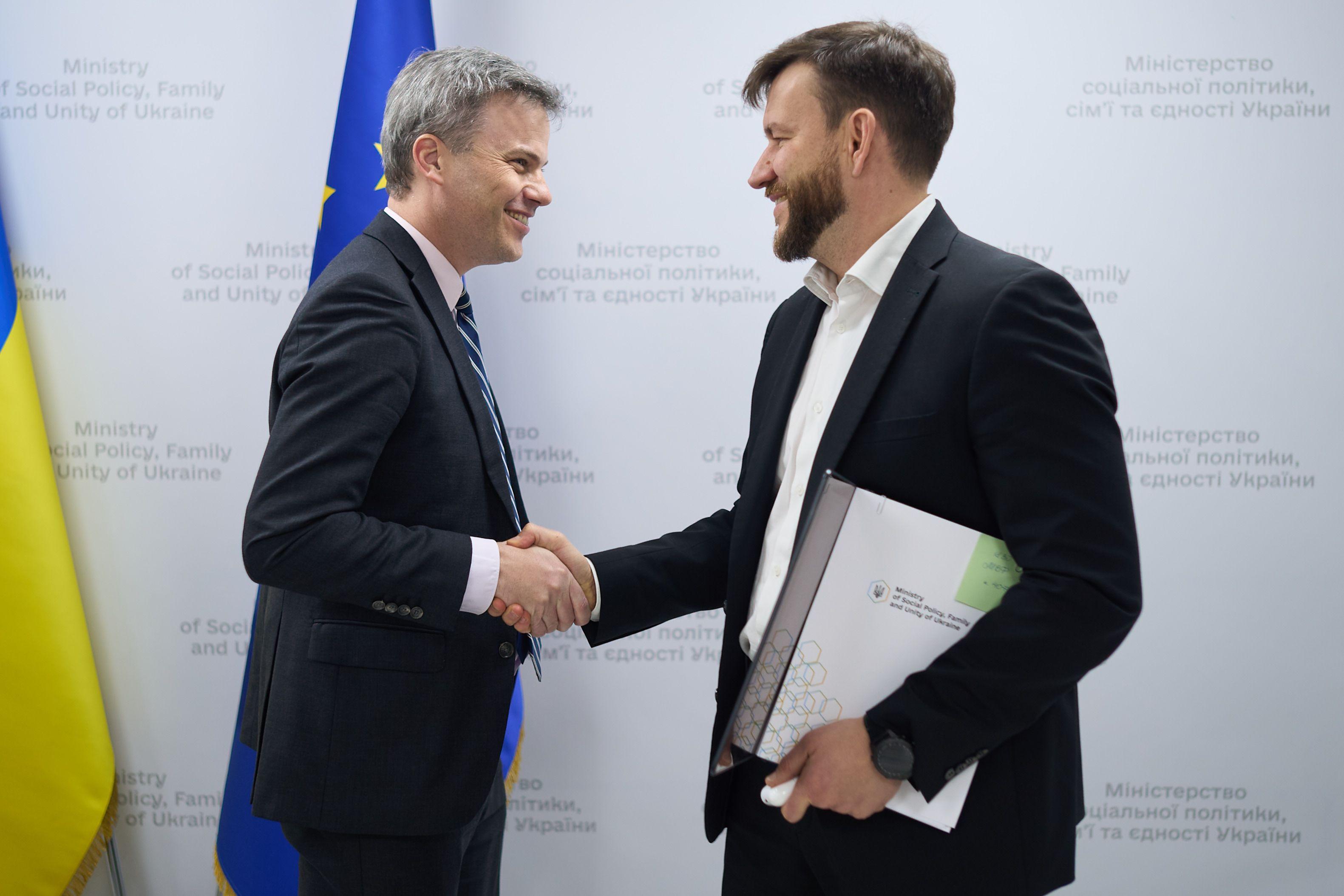 На фото чоловіки вітаються за руку перед зустріччю На фото чоловіки вітаються за руку перед зустріччю