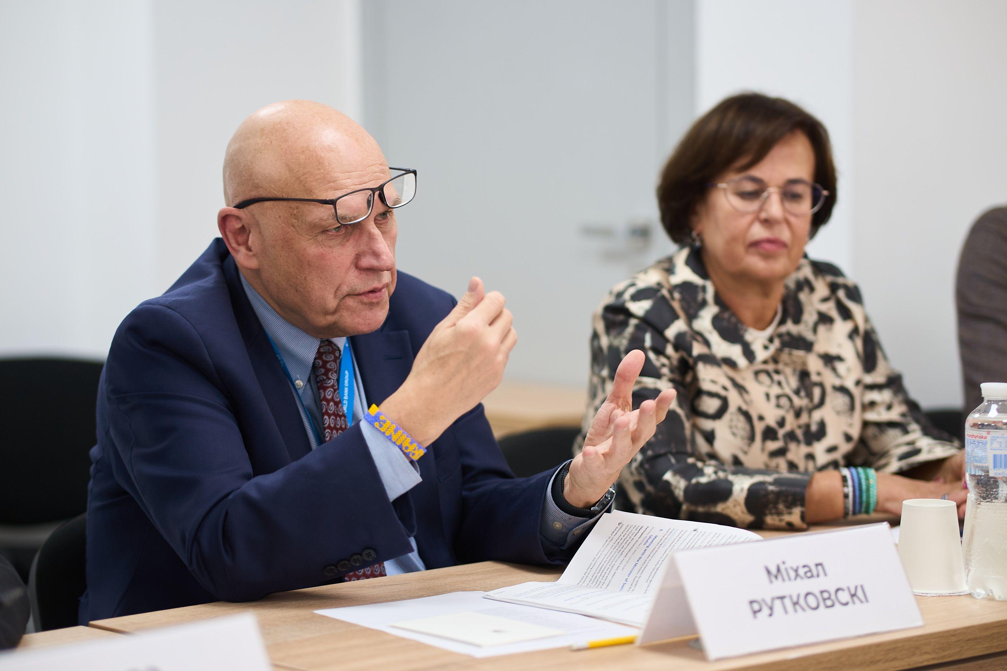 На фото чоловік та жінка сидять за столом під час зустрічі На фото чоловік та жінка сидять за столом під час зустрічі