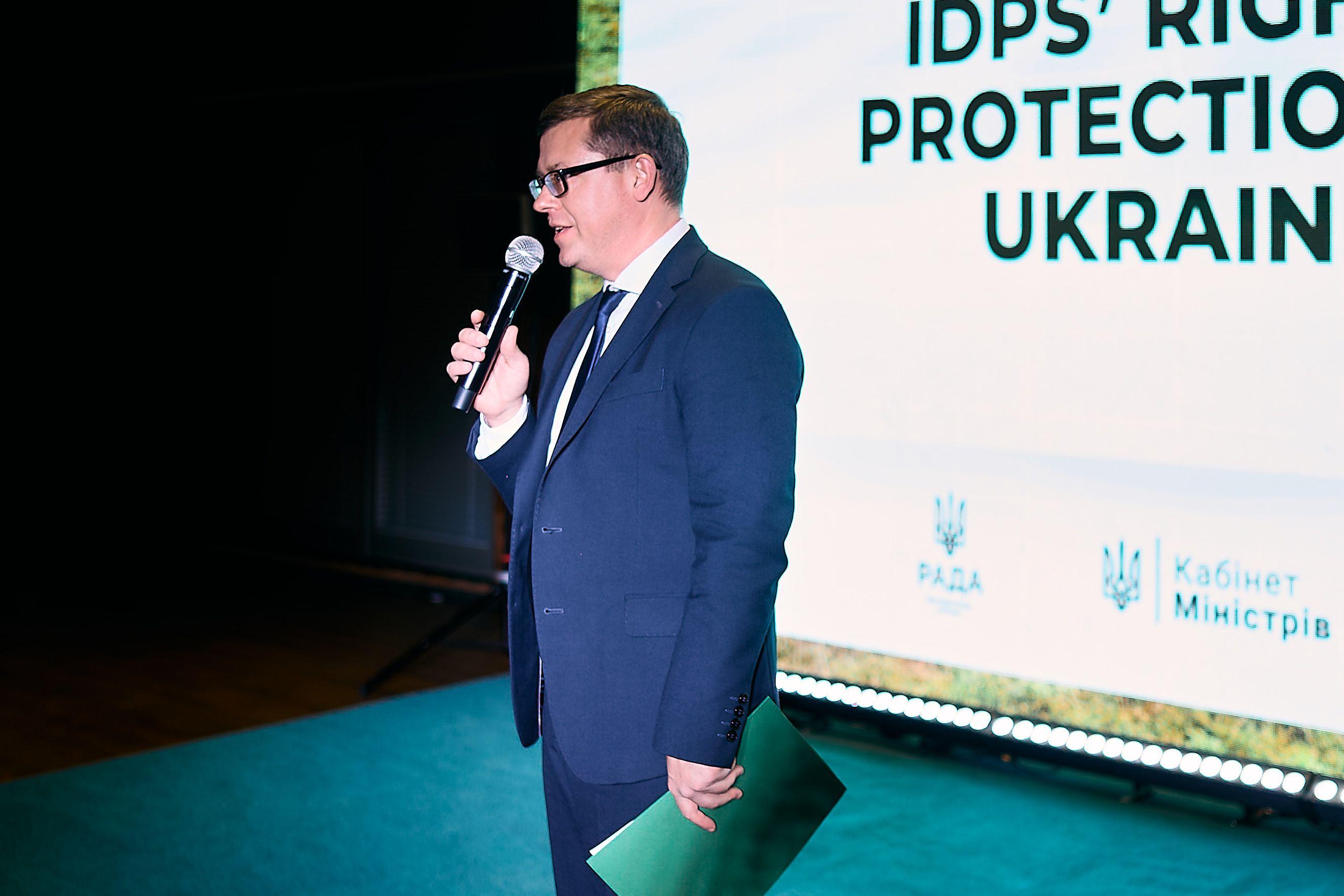 На фото чоловік з мікрофоном виступає під час заходу На фото чоловік з мікрофоном виступає під час заходу