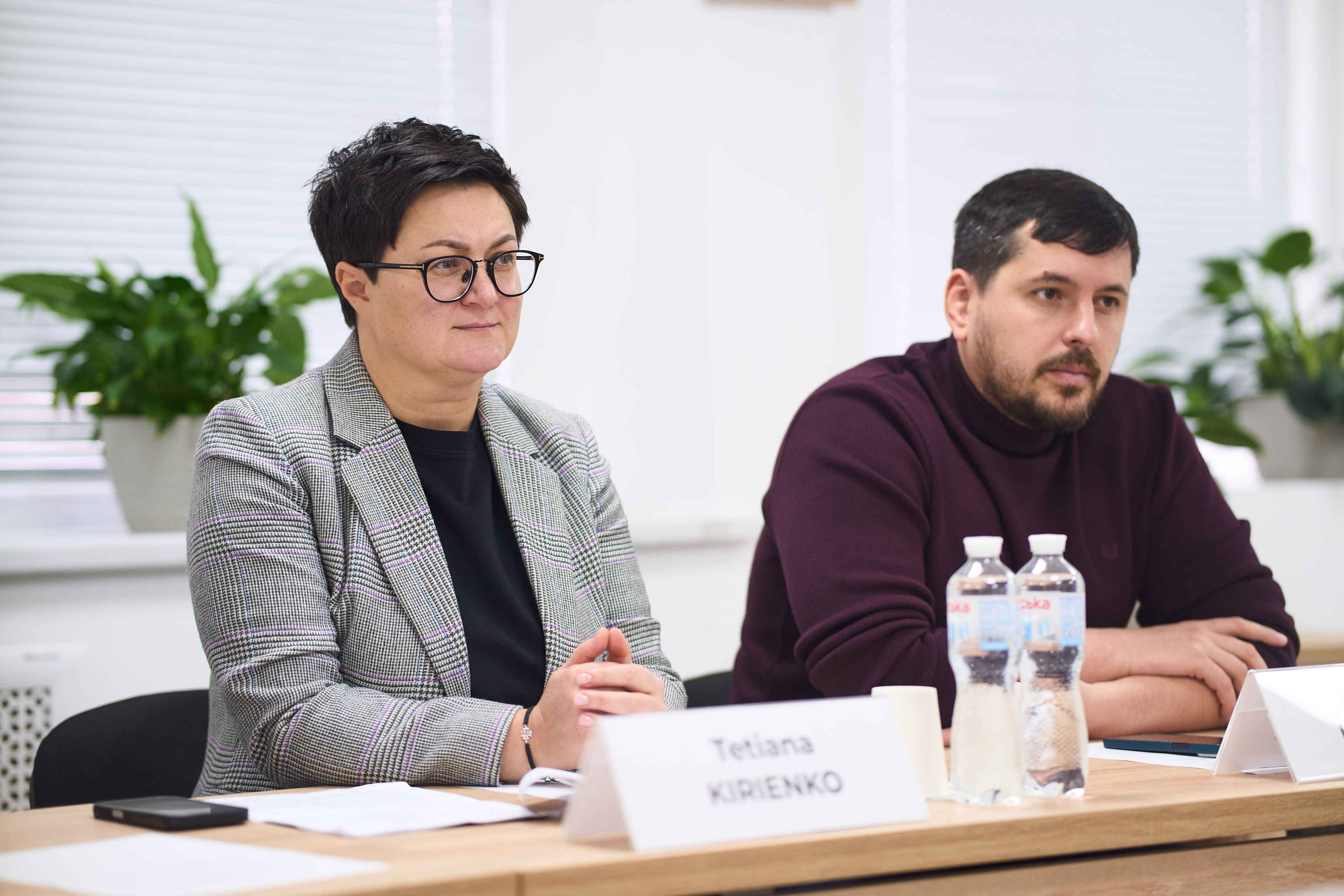 На фото чоловік та жінка сидять за столом під час зустрічі На фото чоловік та жінка сидять за столом під час зустрічі