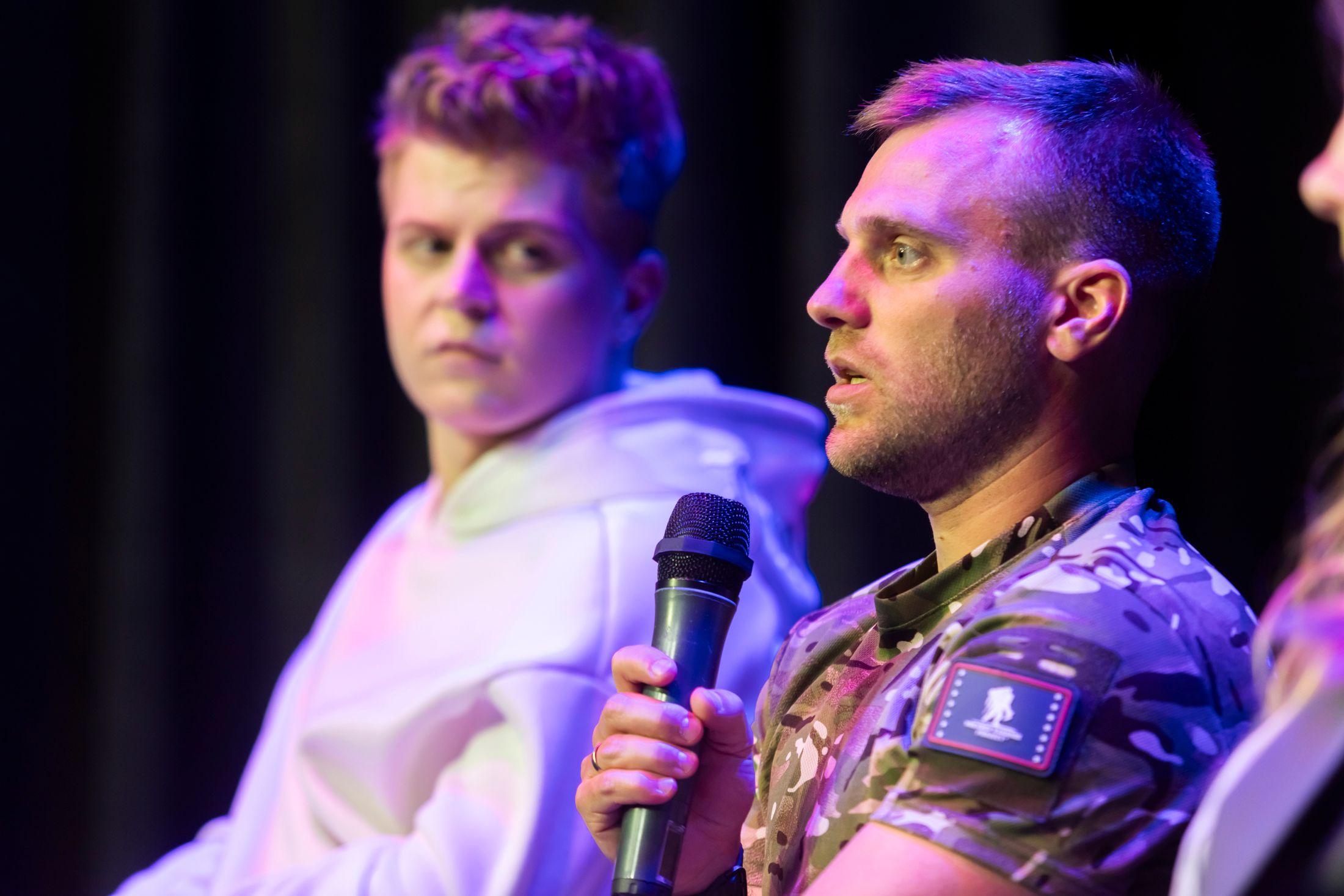 На фото чоловік з мікрофоном виступає під час заходу На фото чоловік з мікрофоном виступає під час заходу