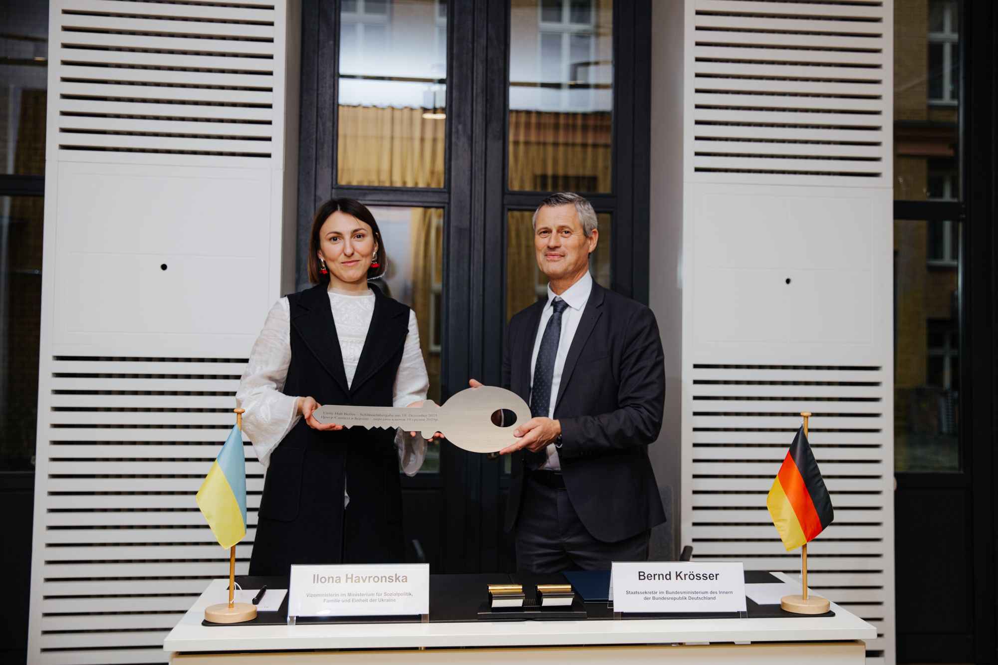 На фото жінка та чоловік тримають в руках символічний ключ На фото жінка та чоловік тримають в руках символічний ключ