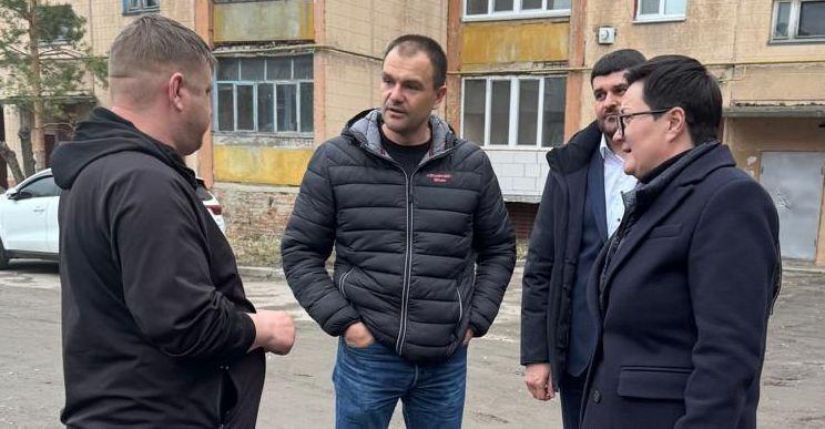 На фото жінки та чоловіки спілкуються на вулиці На фото жінки та чоловіки спілкуються на вулиці
